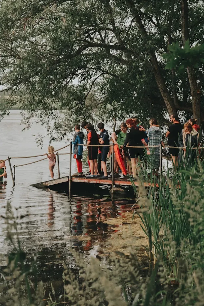 People gathered on the jetty at the water's edge